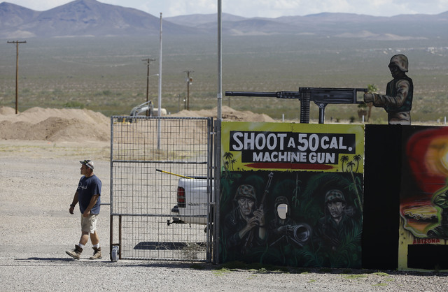A man closes off an entrance to the Last Stop outdoor shooting range Wednesday, Aug. 27, 2014, in White Hills, Ariz. Gun range instructor Charles Vacca was accidentally killed Monday, Aug. 25, 201 ...