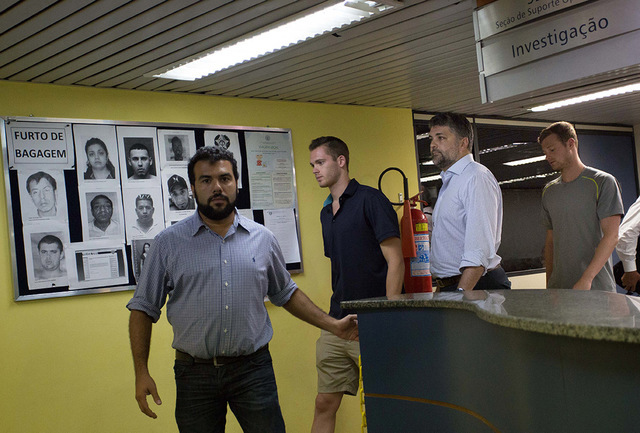 Accompanied by Brazilian lawyer Sergio Viegas, second from right, American Olympic swimmers Gunnar Bentz, center, and Jack Conger, right, leave the police station at Rio International airport earl ...