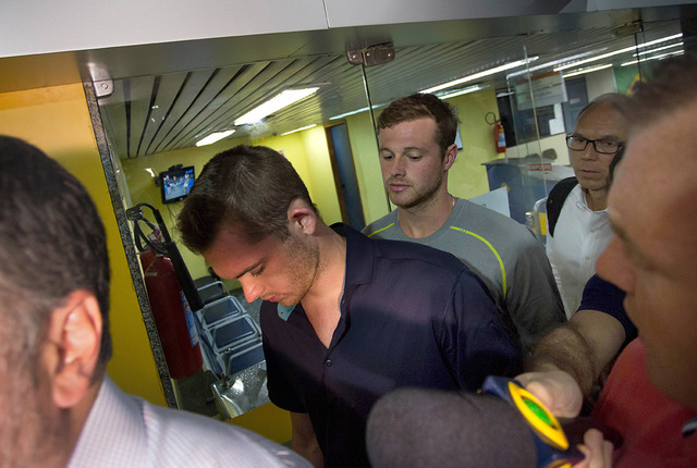 American Olympic swimmers Gunnar Bentz, center left, and Jack Conger, center right, leave the police station at Rio International airport early Thursday Aug. 18, 2016. The two were taken off their ...
