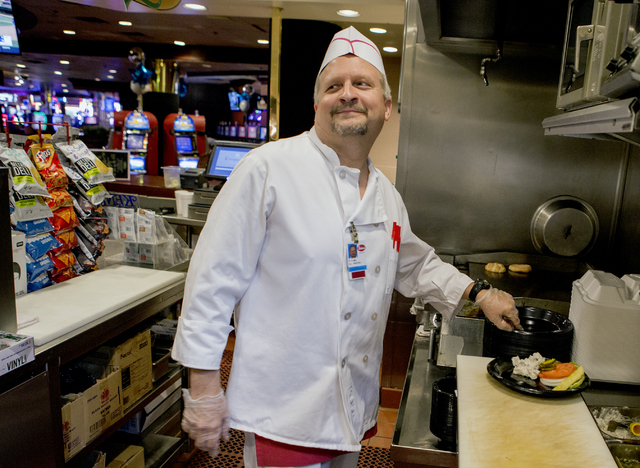 Mel Jones, who has worked for 35 years at Binion's Gambling Hall & Hotel, 128 Fremont St., prepares a hamburger at  the deli on Friday, Aug. 12, 2016. The downtown casino is celebrating its 65 ...