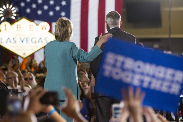 Democratic presidential nominee Hillary Clinton, left, and U.S. Sen. Harry Reid take the stage for a campaign rally at the International Brotherhood of Electrical Workers headquarters on Thursday, ...