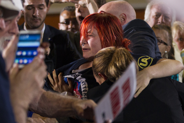 An animal activist who jumped over a barrier to get to Democratic presidential candidate Hillary Clinton is restraint by Secret Service agents during a campaign rally at the International Brotherh ...