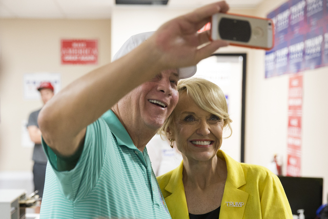 Former Arizona Gov. Jan Brewer, right, takes a photo with local businessman Dan Stansbury during the grand opening for the new campaign office for Republican presidential candidate Donald Trump in ...