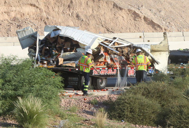 Workers remove spilled contents after a truck rolls over in the eastbound lanes of the 215 Beltway, near the airport connector, Wednesday, Aug. 24, 2016. (Bizuayehu Tesfaye/Las Vegas Review-Journa ...