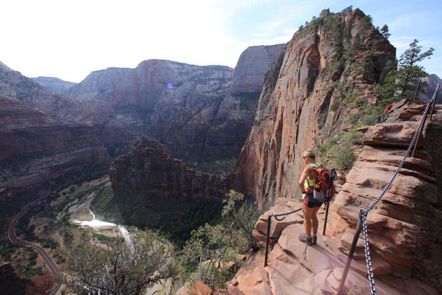 Petita Abblitt, 63, takes in the view of the canyon below while hiking Angels Landing, a 5-mile round-trip trail that climbs 1,500 feet up to the peak, in Utah's Zion National Park. (Rachel Crosby ...