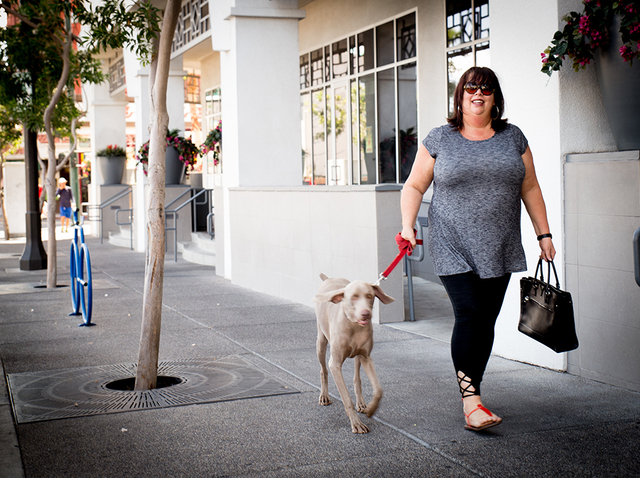 Christine Carlson takes Fitz for a walk downtown. (Tonya Harvey/Real Estate Millions)