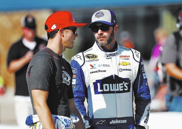 Trevor Bayne, left, talks with Jimmie Johnson before qualifications for the NASCAR Sprint Cup Series auto race at Michigan International Speedway, in Brooklyn, Mich., Friday, Aug. 26, 2016. (AP Ph ...