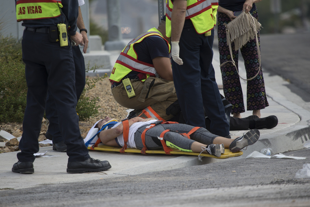 A victim from a two car crash lays on a stretcher with paramedics at the intersection of North Fort Apache Road and West Lone Mountain Road is seen on Wednesday, Aug. 24, 2016, in Las Vegas. Erik  ...
