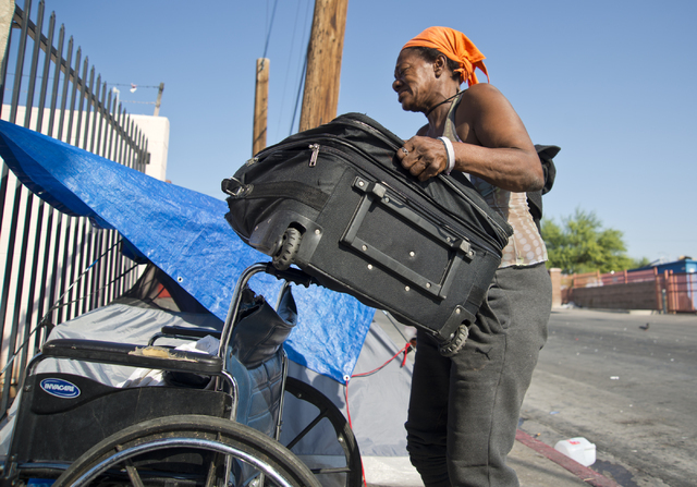 Kathy Washington, who became homeless after her home burned down five weeks ago, packs her things up at a makeshift campsite along Foremaster Lane in downtown Las Vegas on Friday, Aug. 5, 2016. Da ...