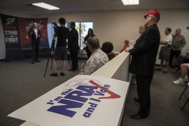 Volunteers and attendees listen to Robert Uithoven, NRA Nevadans for Freedom campaign manager, during the grand opening for a National Rifle Association campaign office at 6375 S. Pecos Road in La ...