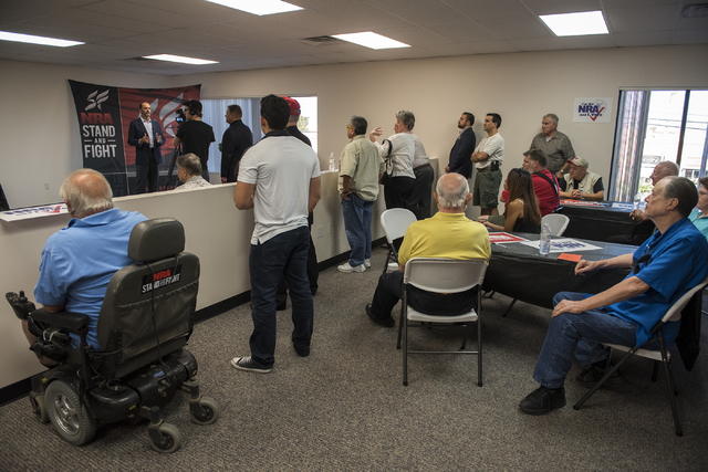Volunteers and attendees listen to Robert Uithoven, NRA Nevadans for Freedom campaign manager, during the grand opening for a National Rifle Association campaign office at 6375 S. Pecos Road in La ...