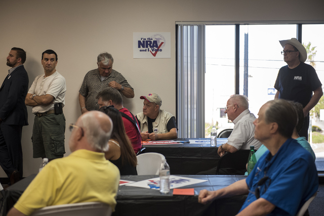 Volunteers and attendees listen to Robert Uithoven, NRA Nevadans for Freedom campaign manager, during the grand opening for a National Rifle Association campaign office at 6375 S. Pecos Road in La ...
