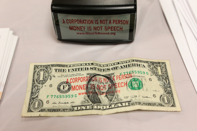 A stamped dollar bill and a stamper are shown at the Move to Amend information table during the &quot;Our Revolution&quot; kickoff party at the Veterans of Foreign Wars Center, 4337 N Las  ...