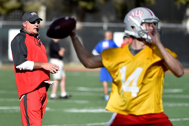 UNLV football head coach Tony Sanchez watches his team run drills, including quarterback Kurt Palandech (14), during the first day of spring practice at Rebel Park at UNLV on Monday, March 16, 201 ...