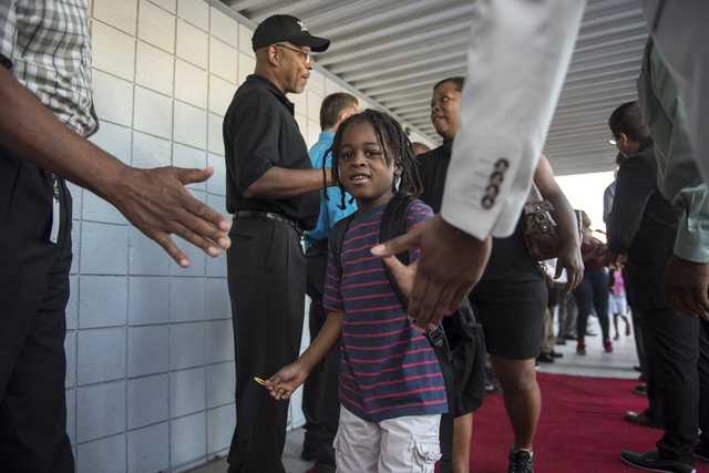 A student is greeted by over 100 male role models on the first day of school at Matt Kelly Elementary School in Las Vegas on Monday, Aug. 29, 2016. Nevada Youth Network recruited over 100 male rol ...