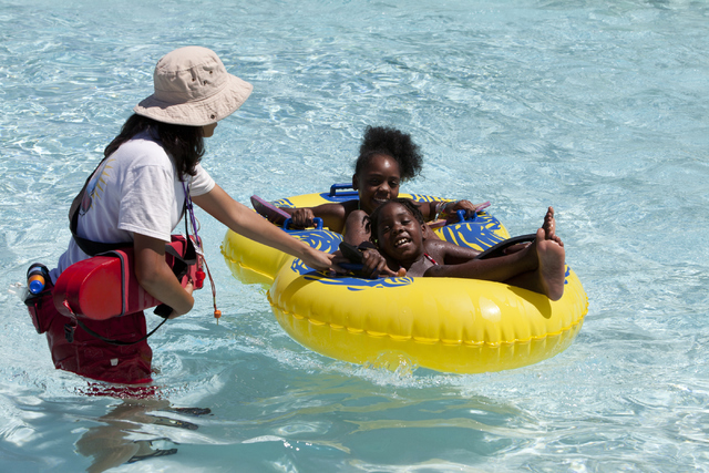 Cowabunga Bay Las Vegas employee pulls in siblings Ahmyah and Ahkijah's raft after they went down the Point Panic ride at the Cowabunga Bay Las Vegas water park in Henderson on Wednesday, June 13, ...