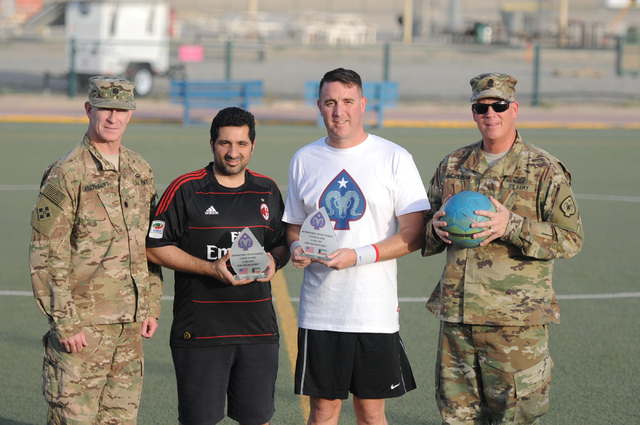 Maj. Beau Vinateiri, second from right, personnel officer in charge of the 17th Sustainment Brigade, gives a memento to a member of the Kuwaiti Police Department on June 2 at CampArifjan, Kuwait.  ...