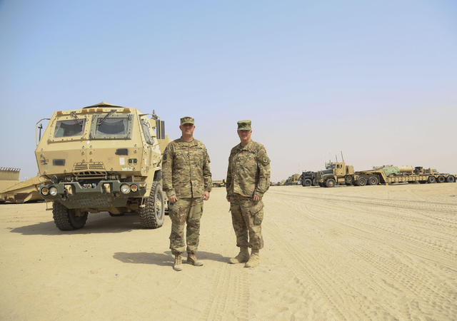 Maj. Beau Vinatieri, left, personnel officer in charge of the 17th Sustainment Brigade, and Col. Vernon L. Scarbrough, commander of 17SB, stand among some of the trucks and trailers used to transp ...