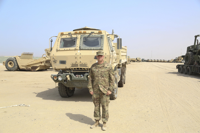 Maj. Beau Vinatieri, personnel officer in charge of the 17th Sustainment Brigade, stands beside a truck used to transport supplies in Camp Arifjan, Kuwait, on June 30, 2016. (Courtesy/Staff Sgt. V ...
