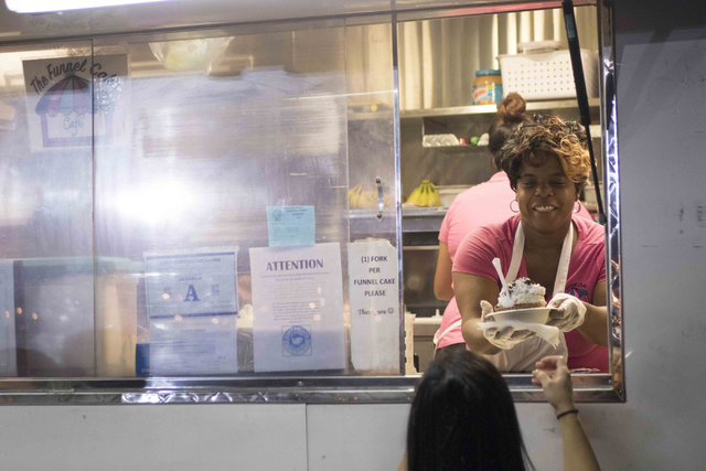 The Funnel Cake Cafe's Kimberly Hopkins serves a customer while working during the monthly First Friday event in the downtown arts district in Las Vegas on Friday, Aug. 5, 2016. (Richard Brian/Las ...