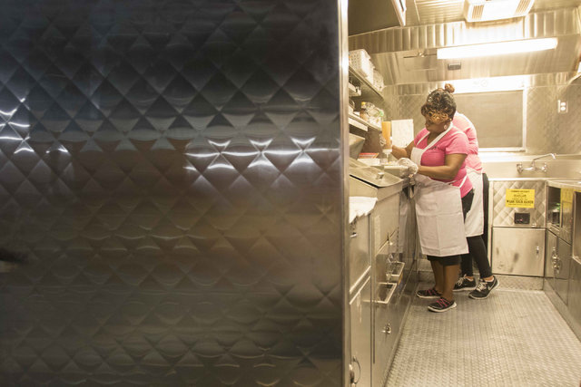 The Funnel Cake Cafe's Kimberly Hopkins adds a topping to a funnel cake while working during the monthly First Friday event in the downtown arts district in Las Vegas on Friday, Aug. 5, 2016. (Ric ...