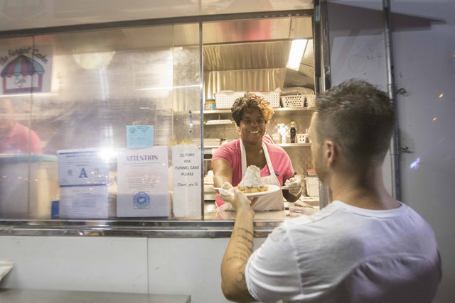 The Funnel Cake Cafe's Kimberly Hopkins helps a guest while working during the monthly First Friday event in the downtown arts district in Las Vegas on Friday, Aug. 5, 2016. (Richard Brian/Las Veg ...