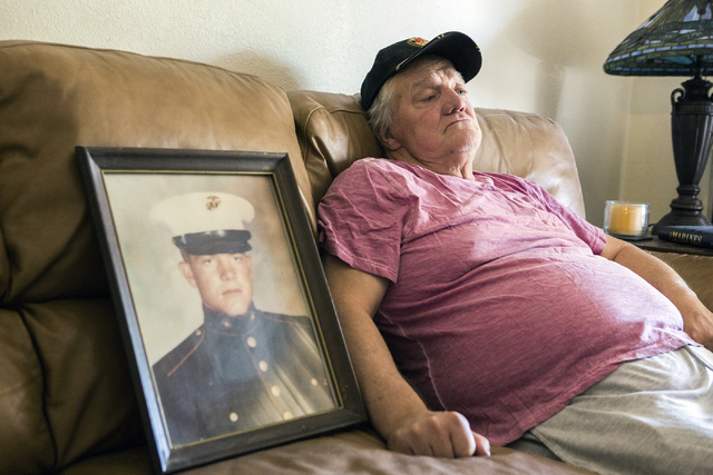 Marine veteran Stanley Furrow sits in the family's home in Las Vegas, Thursday, Aug. 11, 2016. On the left is a photo of him while he as stationed at Marine Corps Base Camp Lejeune, N.C. (Jeff Sch ...