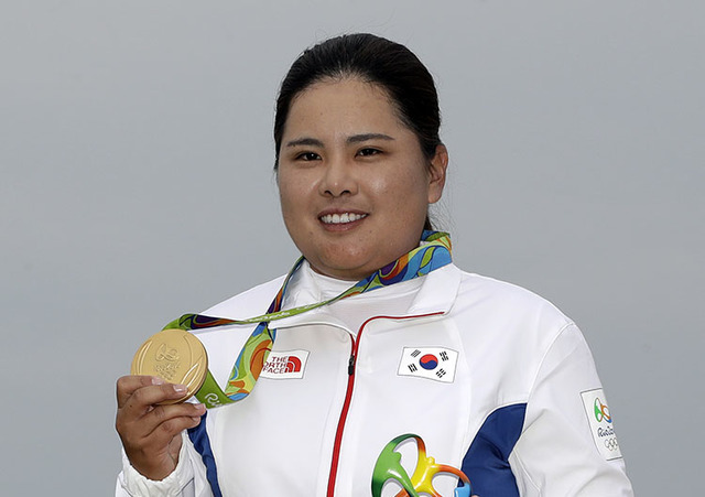 Inbee Park of South Korea holds up her gold medal in Rio de Janeiro, Brazil, Saturday, Aug. 20, 2016. (Chris Carlson/The Associated Press)
