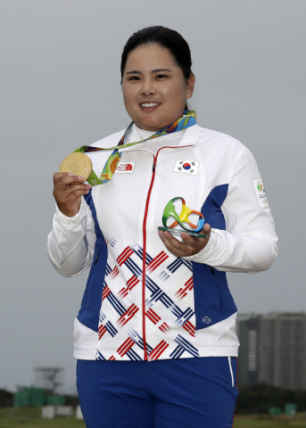Inbee Park of South Korea, holds up her gold medal after the final round of the women's golf event at the 2016 Summer Olympics in Rio de Janeiro, Brazil, Saturday, Aug. 20, 2016. (AP Photo/Chris C ...