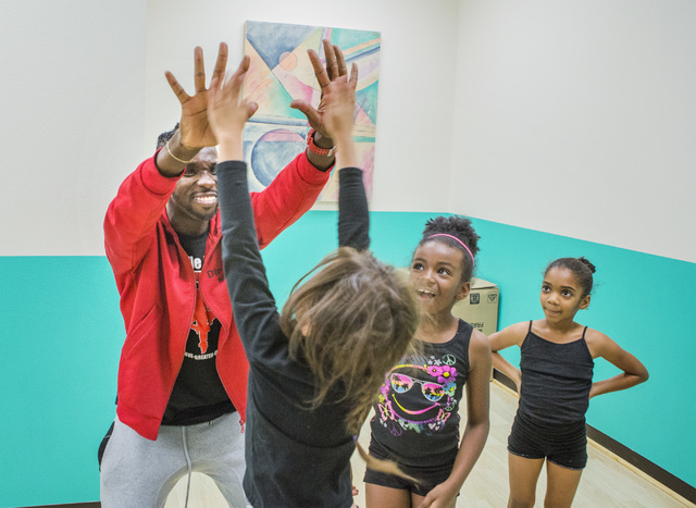 Former Cirque du Soleil dancer Tyrell Rolle high-fives participants in R.A.G.E. (Reaching Above Greater Expectations), part of the non-profit dance education organization now located at his new St ...