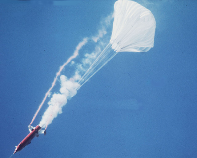 A parachute opens behind the rocket-powered Sky Cycle X-2, containing American motorcycle stuntman Evel Knievel, as he attempts to jump the Snake River Canyon, Idaho, in 1974.  (The Associated Press)