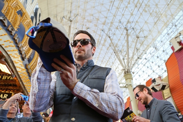 NASCAR drivers Jimmie Johnson, front, and Kurt Busch, back, sign autographs during a NASCAR FanFest event at Fremont Street Experience Wednesday, Dec. 2, 2015, in Las Vegas. (Ronda Churchill/Las V ...