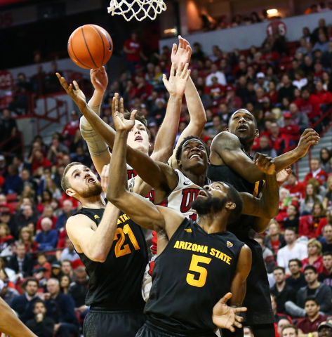 UNLV and Arizona State players, including forward Eric Jacobsen (21) and forward Obinna Oleka (5), reach for a rebound during a basketball game at the Thomas & Mack Center in Las Vegas on Wedn ...