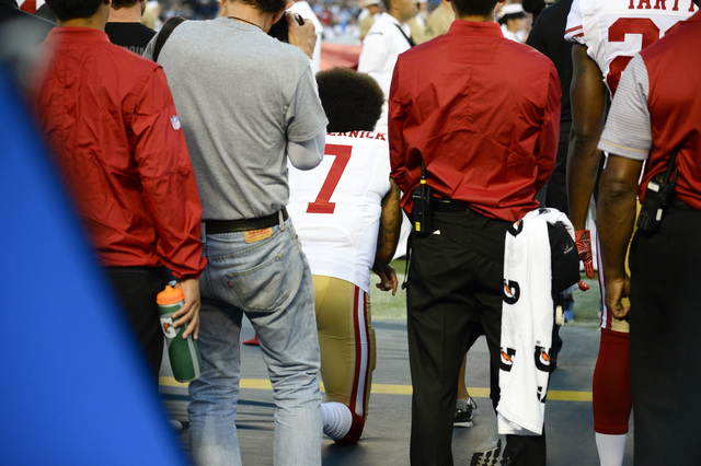 San Francisco 49ers quarterback Colin Kaepernick, middle, kneels during the national anthem before the team's NFL preseason football game against the San Diego Chargers, Thursday, Sept. 1, 2016, i ...