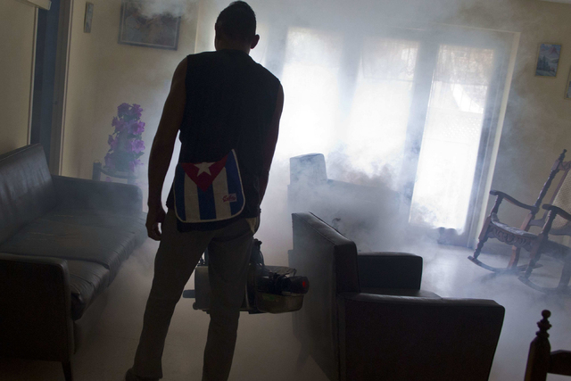 A government fumigator sprays a home for mosquitos in Havana, Cuba, on Friday, Aug. 26, 2016. Cuba's massive bureaucracy has been deployed with remarkable success in the battle against Zika. (Ramo ...