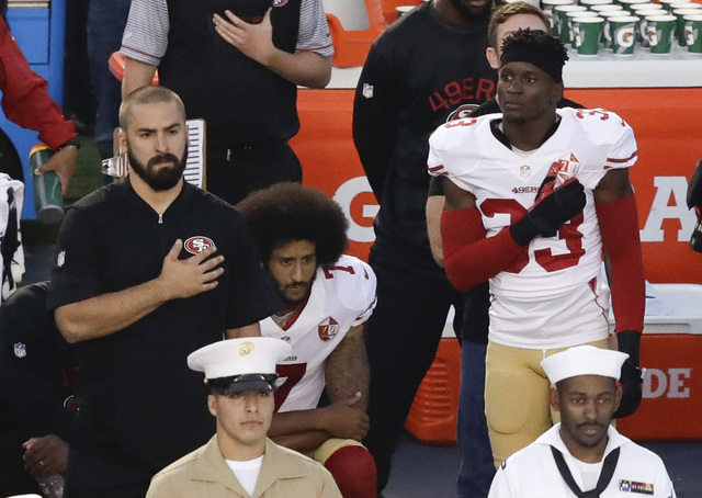 San Francisco 49ers quarterback Colin Kaepernick, middle, kneels during the national anthem before the team's NFL preseason football game against the San Diego Chargers, Thursday, Sept. 1, 2016, i ...