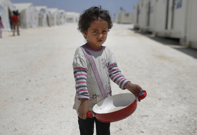 FILE - In this June 19, 2015 file photo, a Syrian refugee child walks at a refugee camp in Suruc, on the Turkey-Syria border. (Emrah Gurel/AP)