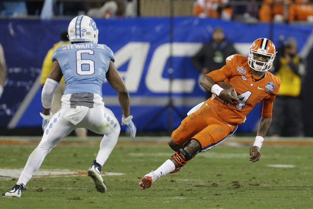 In this Saturday, Dec. 5, 2015 file photo, Clemson quarterback Deshaun Watson (4) runs the ball as North Carolina's M.J. Stewart (6) moves in for the tackle during the first half of the Atlantic C ...
