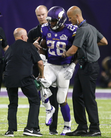 Minnesota Vikings running back Adrian Peterson (28) is helped off the field after getting injured during the second half of an NFL football game against the Green Bay Packers Sunday, Sept. 18, 201 ...