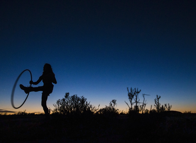 Allison Messick plays with a hula hoop at dusk during the seventh annual Wasteland Weekend on Friday, Sept. 23, 2016, in California City, Calif. The four day, post-apocalyptic festival takes place ...
