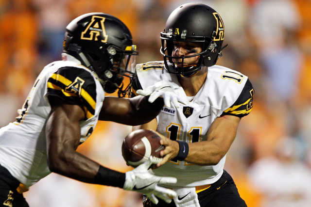 Appalachian State quarterback Taylor Lamb (11) hands the ball off to running back Jalin Moore during the first half of an NCAA college football game against Tennessee Thursday, Sept. 1, 2016 in Kn ...