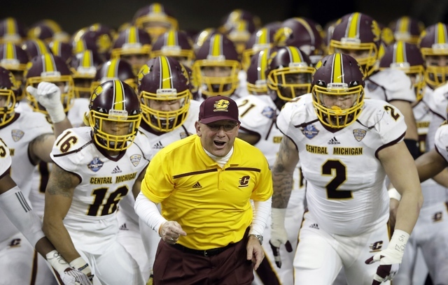 Central Michigan head coach John Bonamego leads the team out onto the field before the first half of the Quick Lane Bowl NCAA college football game against Minnesota, Monday, Dec. 28, 2015, in Det ...