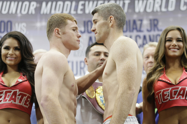 Canelo Alvarez, center left, and Liam Smith, center right, face off after the official weigh-in for their upcoming tittle fight at the stadium in Arlington, Texas, Thursday, Sept. 15, 2016. (LM Ot ...