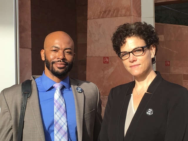 Defense attorneys Jonathan MacArthur and Monique McNeill wear Black Lives Matter pins Wednesday as they stand outside the Regional Justice Center in downtown Las Vegas. (photo by David Ferrara)