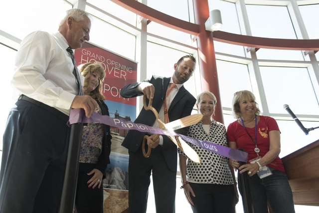 At Boulder City Municipal Airport, Geoff Edlund, president of Papillon Grand Canyon Helicopters, center, cuts the ribbon during a ceremony for the company's new Hoover Dam heliport in Boulder City ...