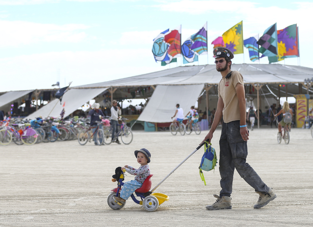 A man pushes a small child around during Burning Man at the Black Rock Desert north of Reno on Wednesday, Aug. 31, 2016. Chase Stevens/Las Vegas Review-Journal Follow @csstevensphoto