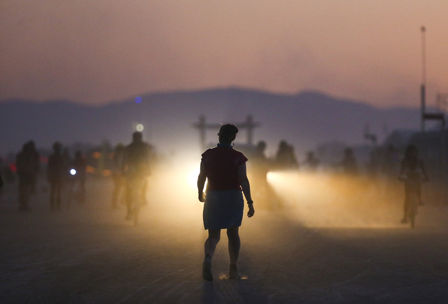 An attendee is silhouetted by the lights of a vehicle during Burning Man at the Black Rock Desert north of Reno on Wednesday, Aug. 31, 2016. Chase Stevens/Las Vegas Review-Journal Follow @cssteven ...