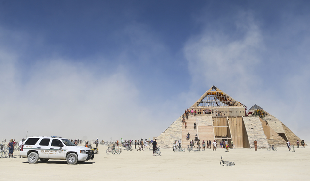 A Washoe County Sheriff vehicle sits on the playa as attendees explore the Catacomb of Veils art installation during Burning Man at the Black Rock Desert north of Reno on Thursday, Sept. 1, 2016.  ...
