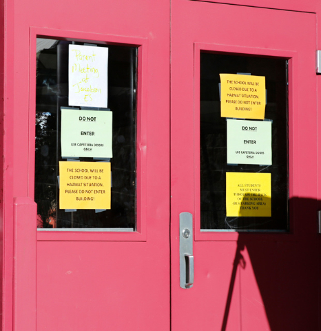 Signs are seen on the door of Johnson Junior High School in Las Vegas, Sunday, Sept. 11, 2016. School officials announced Sunday that Monday classes at the school will be canceled while officials  ...