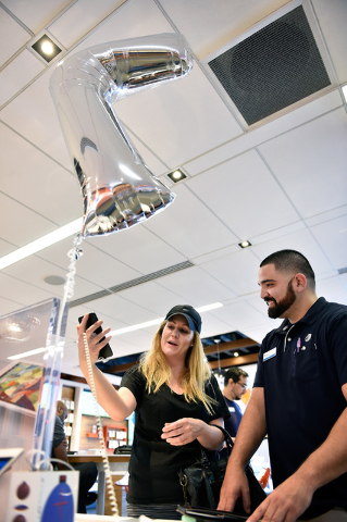 Kim Katunis, left, takes a selfie using an iPhone 7 Plus with the assistance of salesperson Mando Meza at an AT&T store Friday, Sept. 16, 2016, in Las Vegas.  Apple's newest iPhone went on sal ...